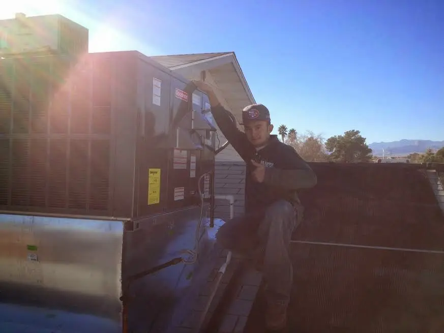 HVAC technician performing Heat Pump Repair on a rooftop unit in Cedar Hills